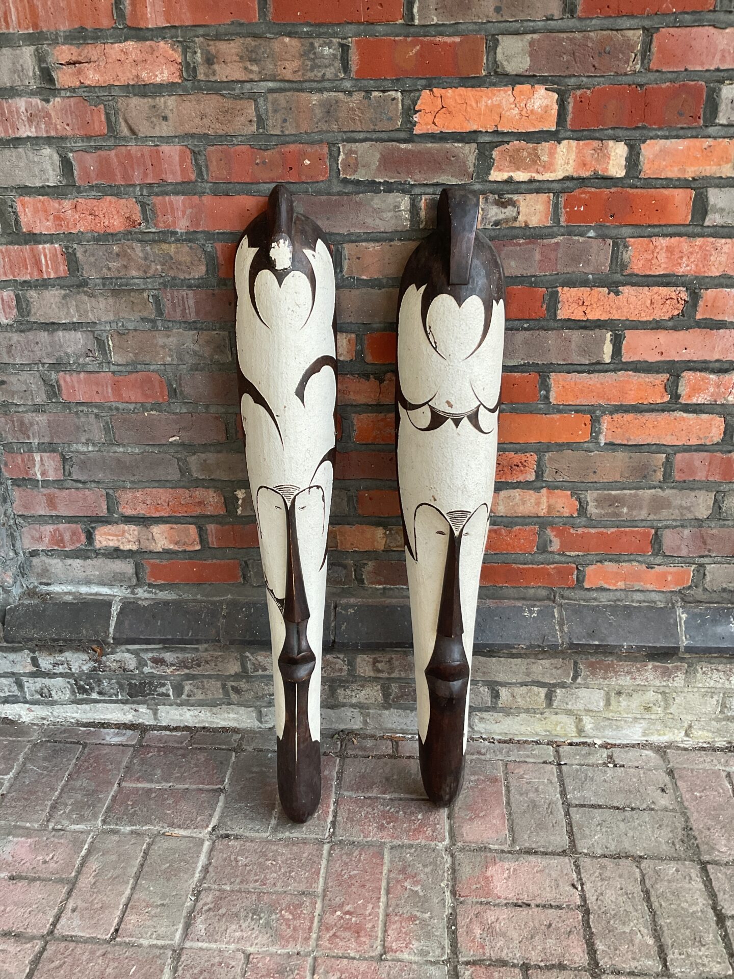 Pair of vintage African carved wooden masks with geometric designs.