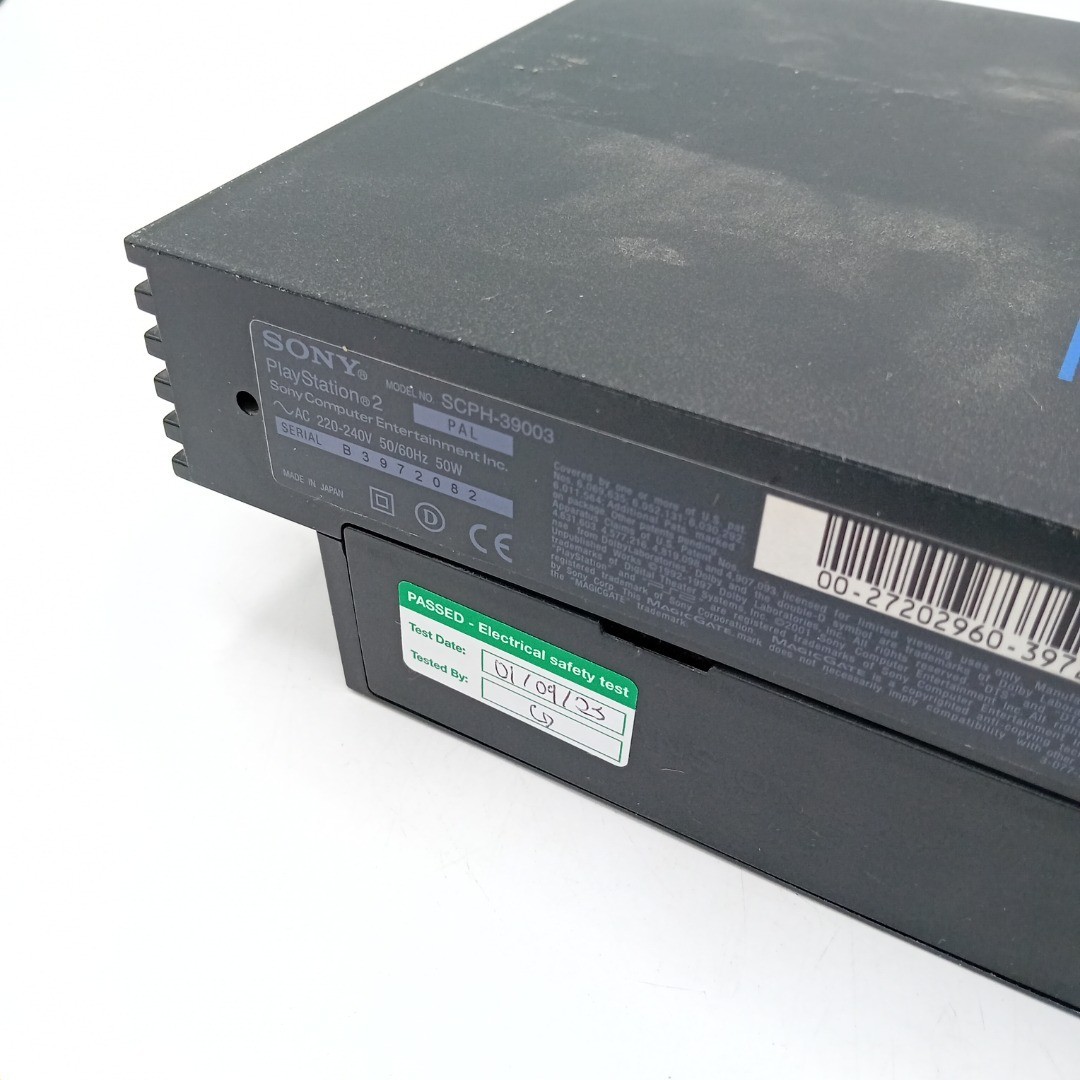 Back of the PlayStation 2 console with safety test label.