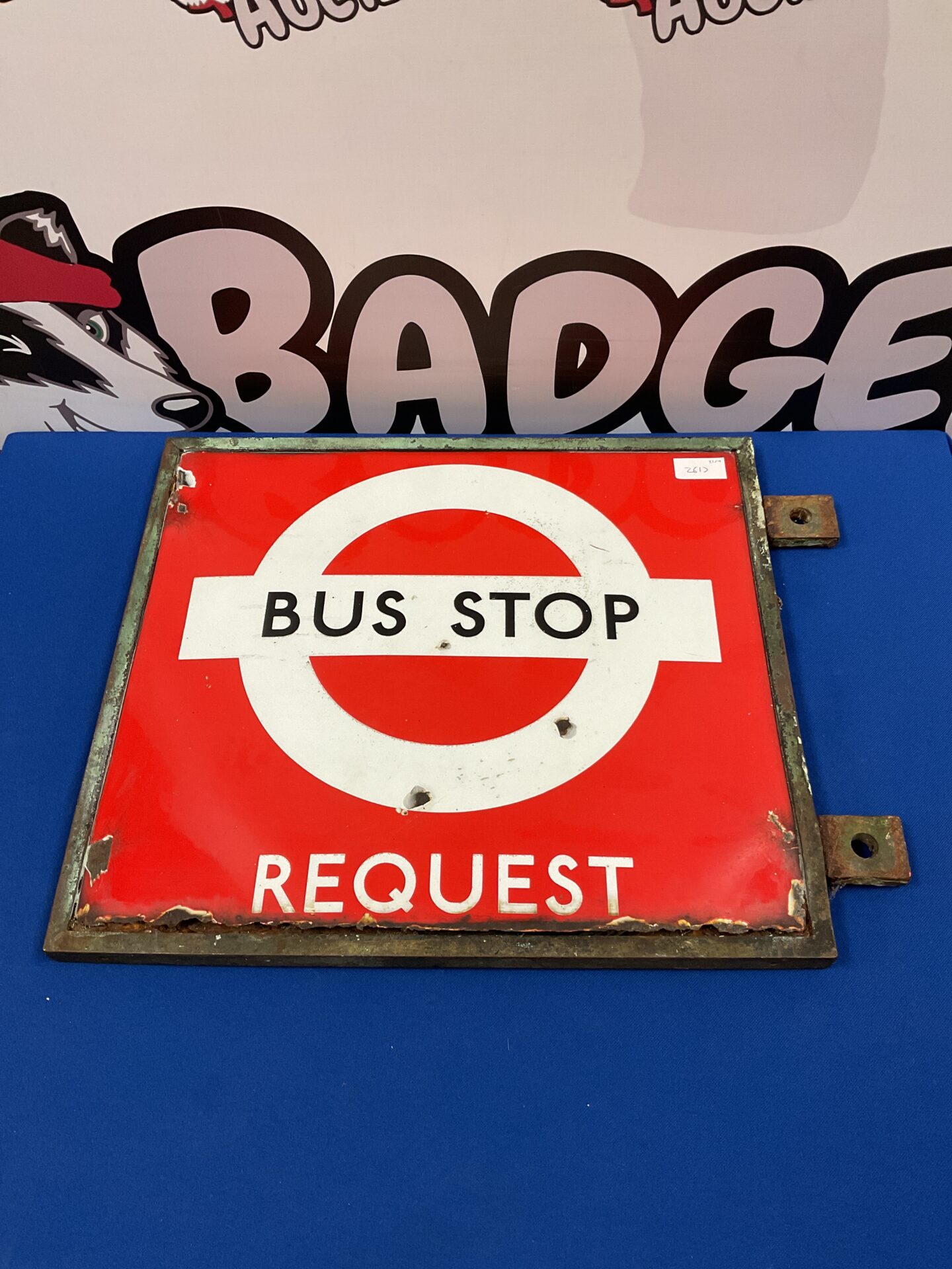 Vintage double-sided enamel bus stop sign in bronze frame.