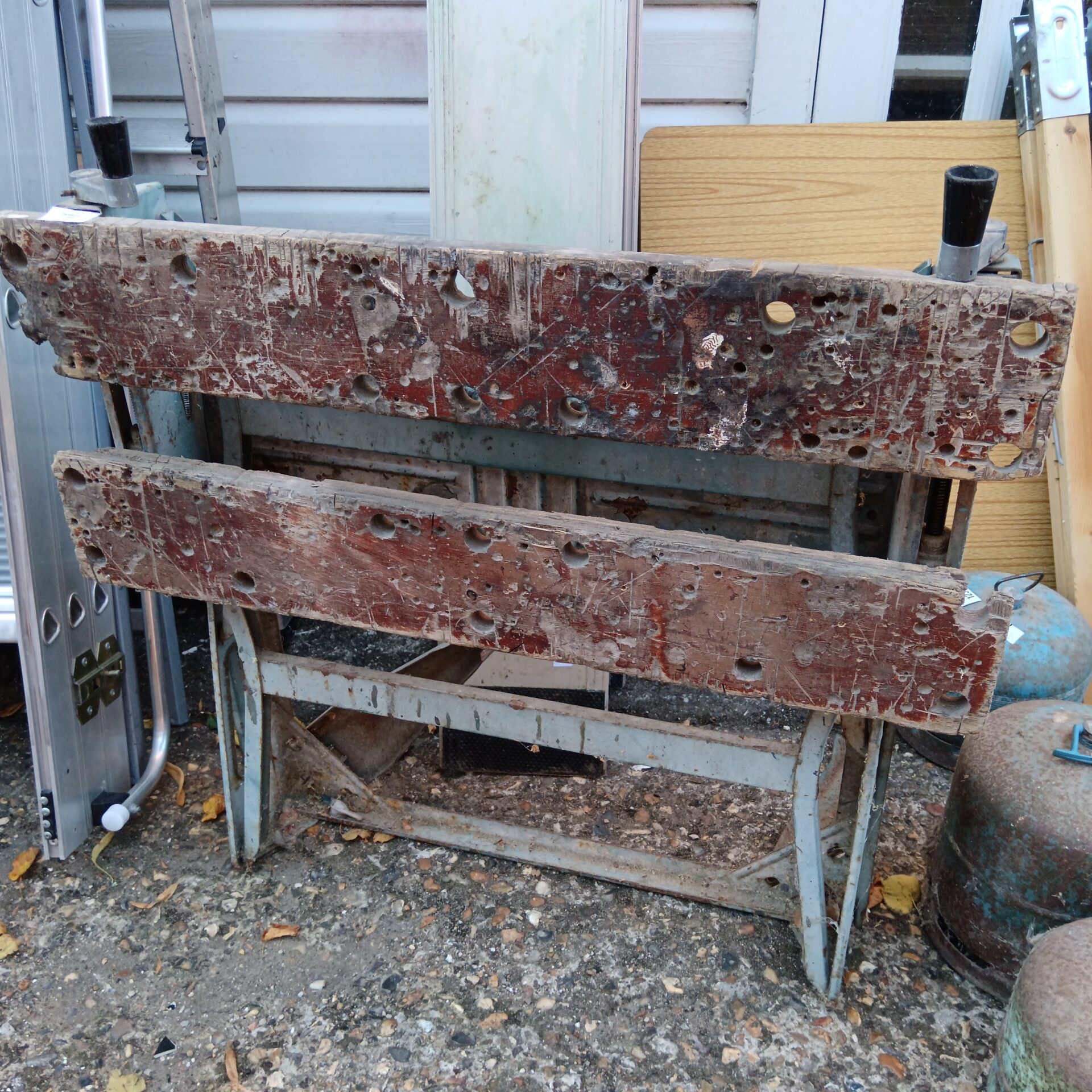 Vintage workbench with metal legs, ideal for woodworking projects.